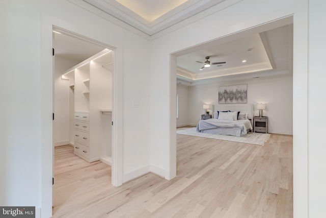 bedroom featuring light wood-type flooring and a tray ceiling