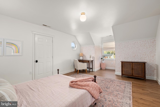 bedroom with hardwood / wood-style flooring and lofted ceiling