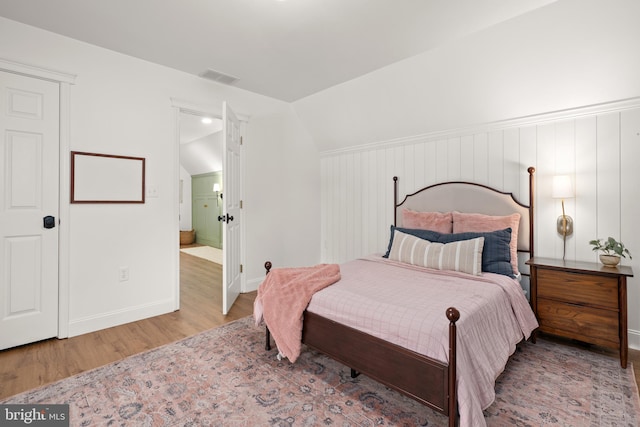 bedroom featuring wood-type flooring and vaulted ceiling