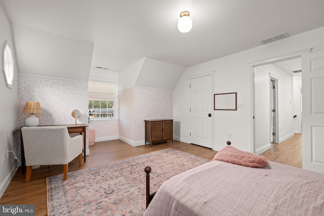 bedroom with vaulted ceiling and light hardwood / wood-style floors