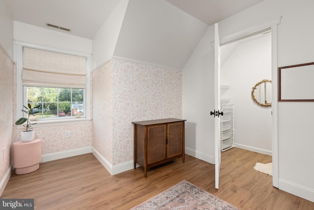 bonus room featuring light wood-type flooring and vaulted ceiling