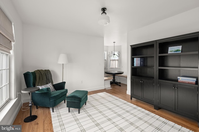 living area featuring a notable chandelier and light hardwood / wood-style floors