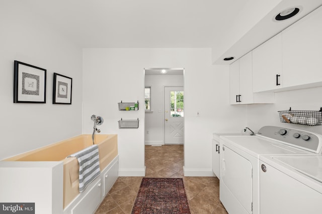 laundry room with light tile patterned floors, sink, washer and dryer, and cabinets