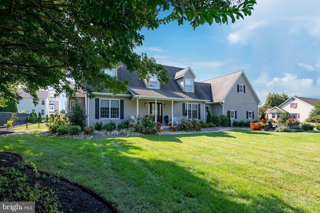 new england style home with a front lawn and covered porch