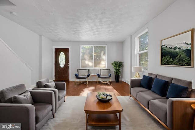 living room with a textured ceiling and light hardwood / wood-style flooring