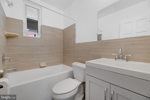 full bathroom with toilet, vanity, tiled shower / bath combo, and tile walls