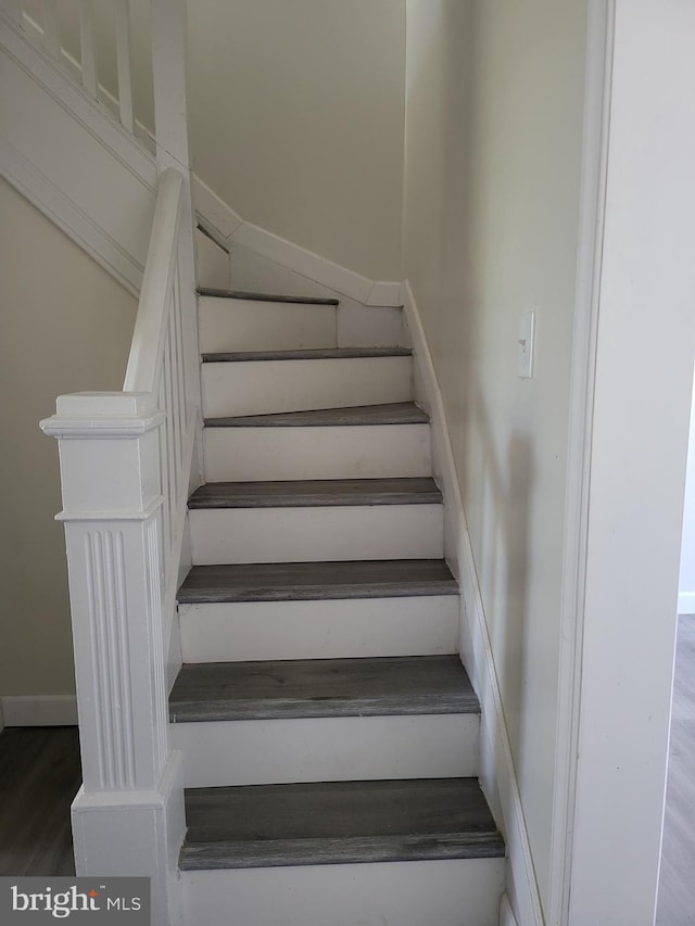 stairs featuring wood finished floors