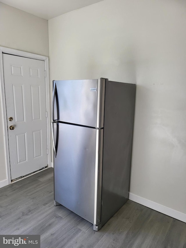 kitchen with wood finished floors, freestanding refrigerator, and baseboards