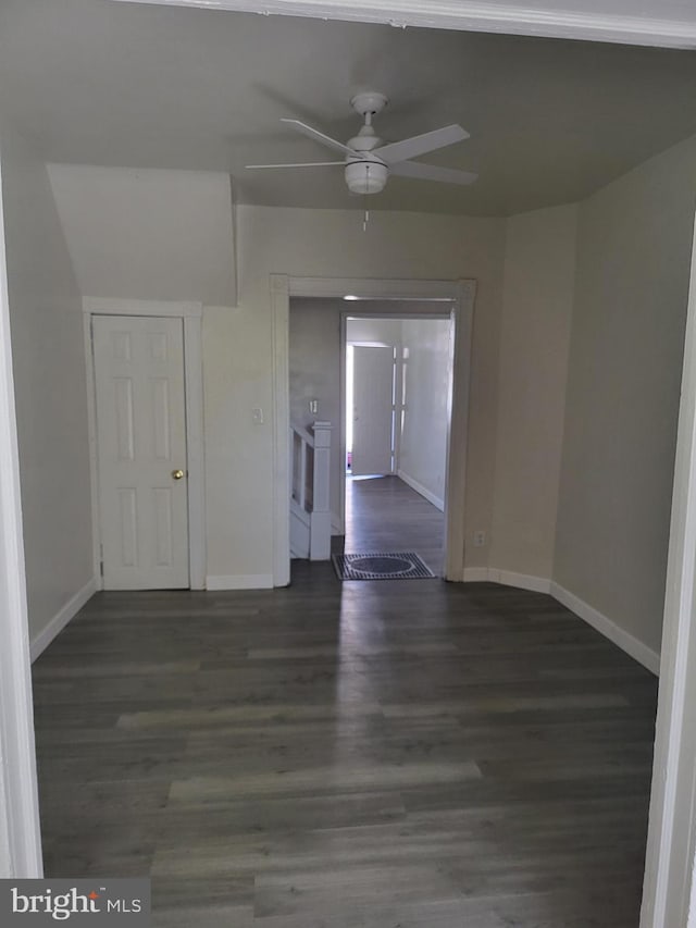 unfurnished room featuring wood finished floors, baseboards, and a ceiling fan
