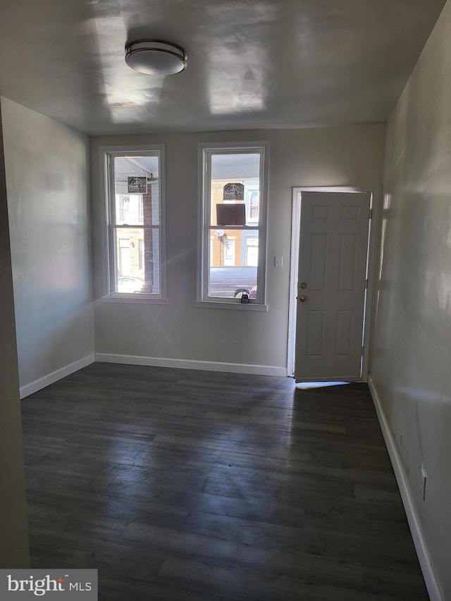 foyer featuring dark wood-style flooring and baseboards