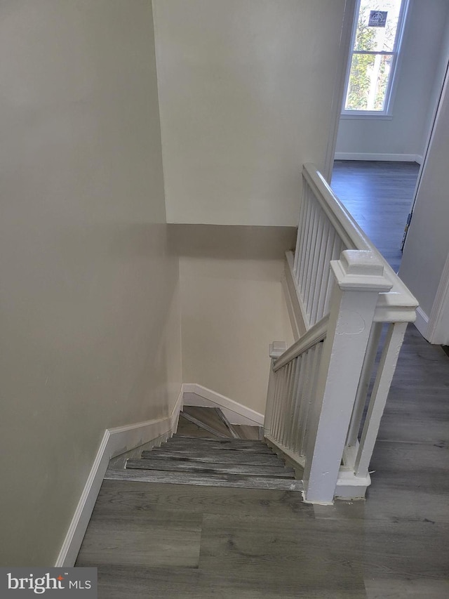 stairway with baseboards and wood finished floors