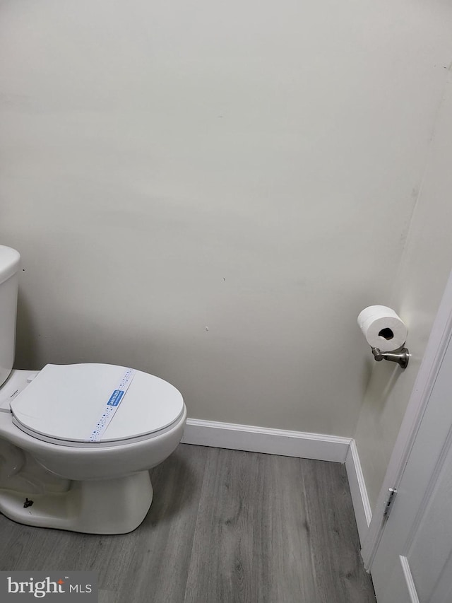 bathroom featuring toilet, baseboards, and wood finished floors