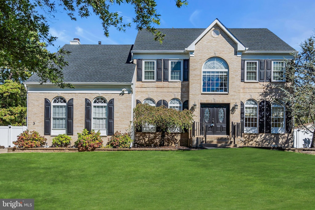 colonial home with a front lawn