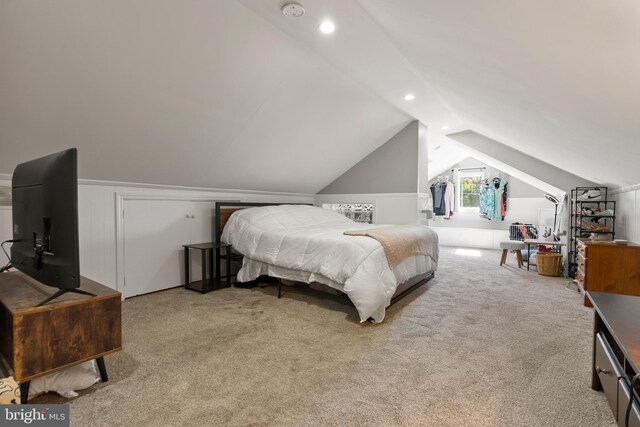 bedroom featuring light colored carpet and vaulted ceiling