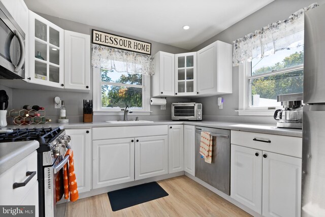 kitchen featuring white cabinets, appliances with stainless steel finishes, and plenty of natural light