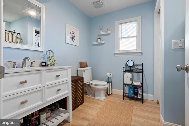 bathroom featuring vanity, hardwood / wood-style flooring, and toilet