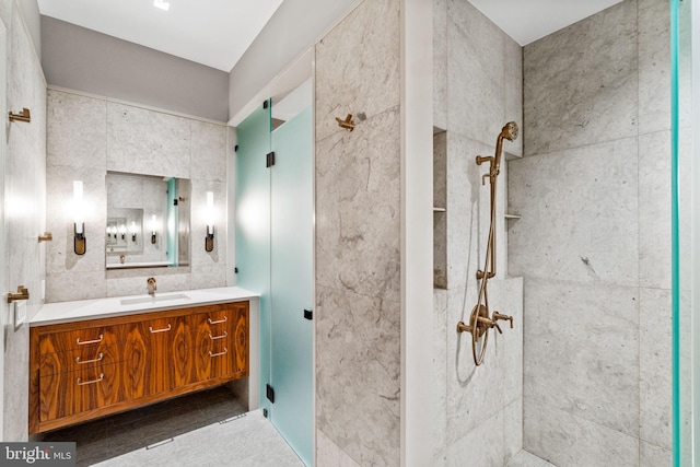 bathroom with tile walls, a shower, and vanity