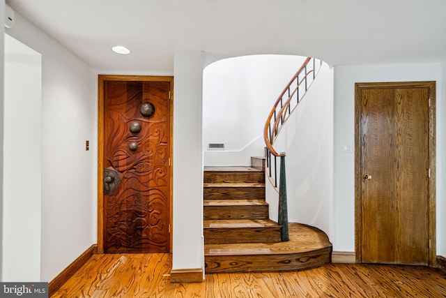 stairs featuring hardwood / wood-style flooring