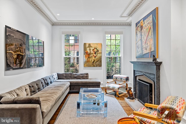 living room with wood-type flooring, a fireplace, and ornamental molding