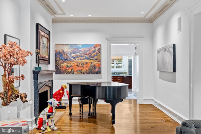 misc room featuring a fireplace, ornamental molding, and hardwood / wood-style flooring