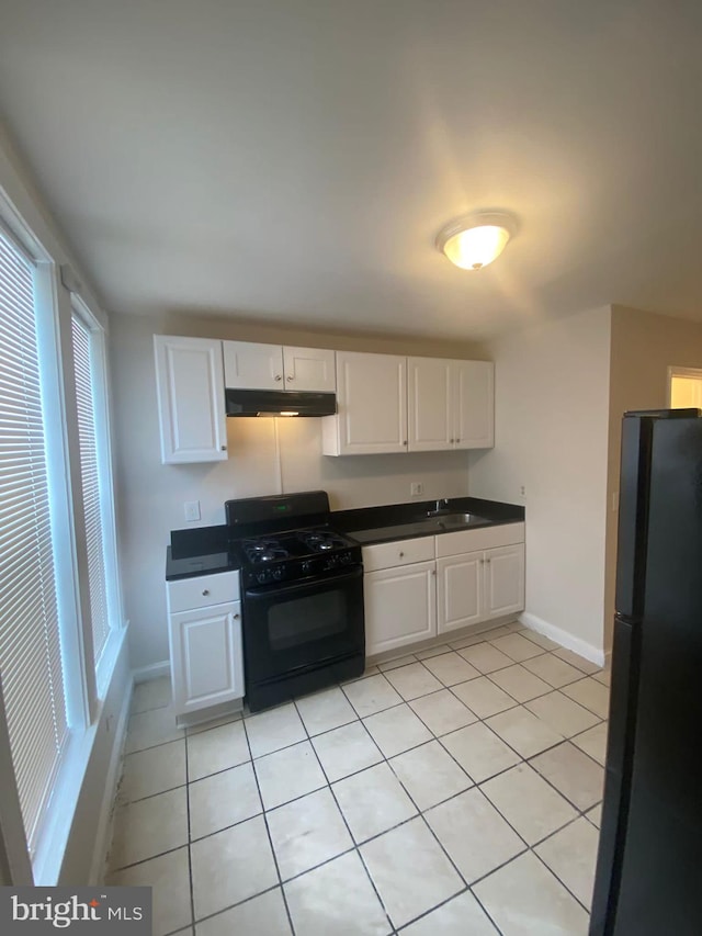 kitchen featuring light tile patterned flooring, sink, white cabinetry, and black appliances