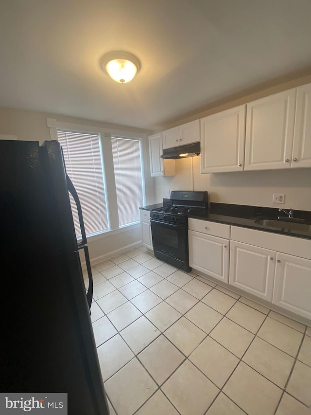 kitchen with white cabinets, black appliances, light tile patterned floors, and sink