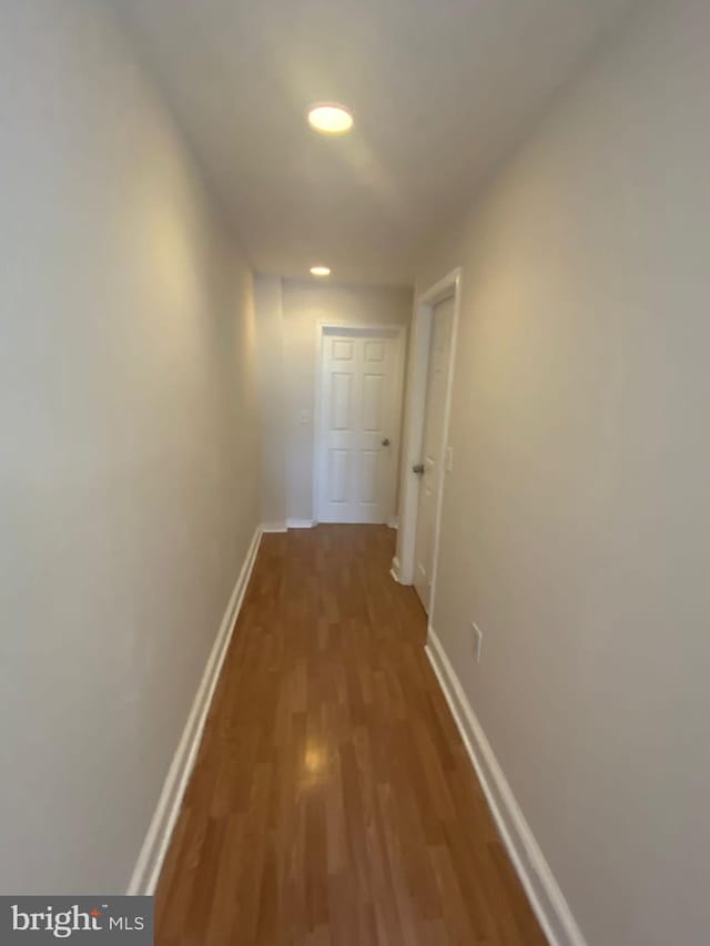 corridor with hardwood / wood-style floors