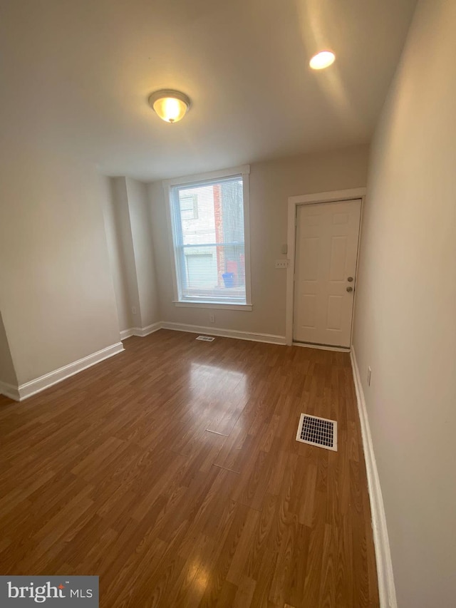 unfurnished room with dark wood-type flooring