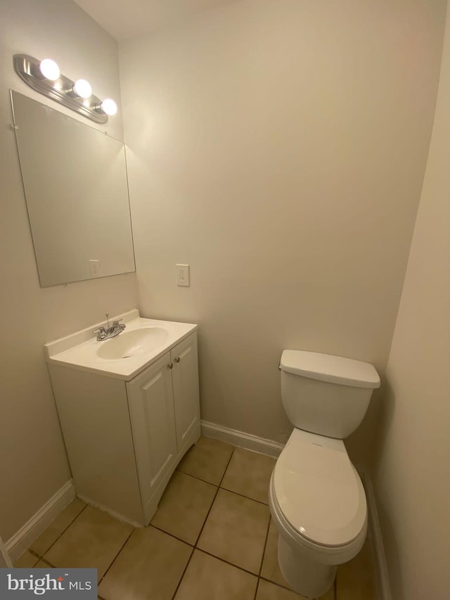 bathroom featuring vanity, tile patterned flooring, and toilet