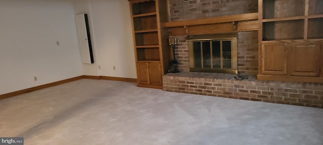 unfurnished living room featuring a fireplace, carpet flooring, and built in shelves