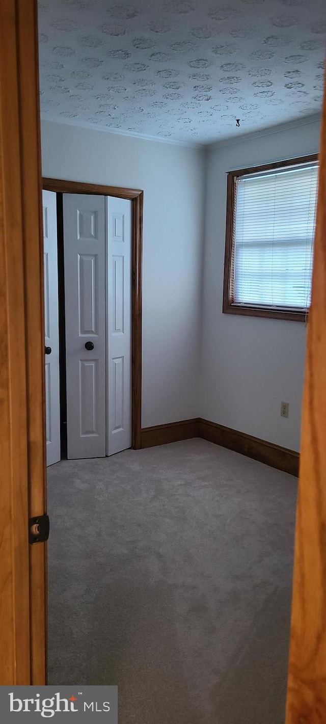 carpeted spare room with a textured ceiling