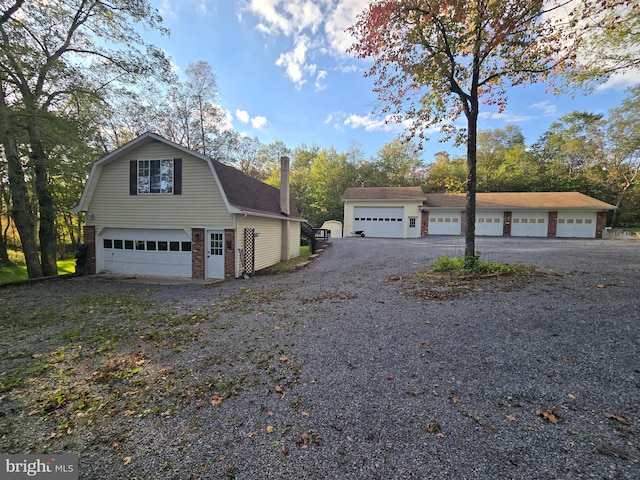 view of front of property with a garage and an outbuilding