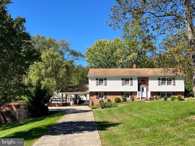 split foyer home featuring a carport and a front lawn