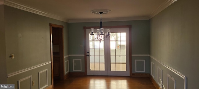 unfurnished dining area featuring crown molding, a notable chandelier, and light wood-type flooring