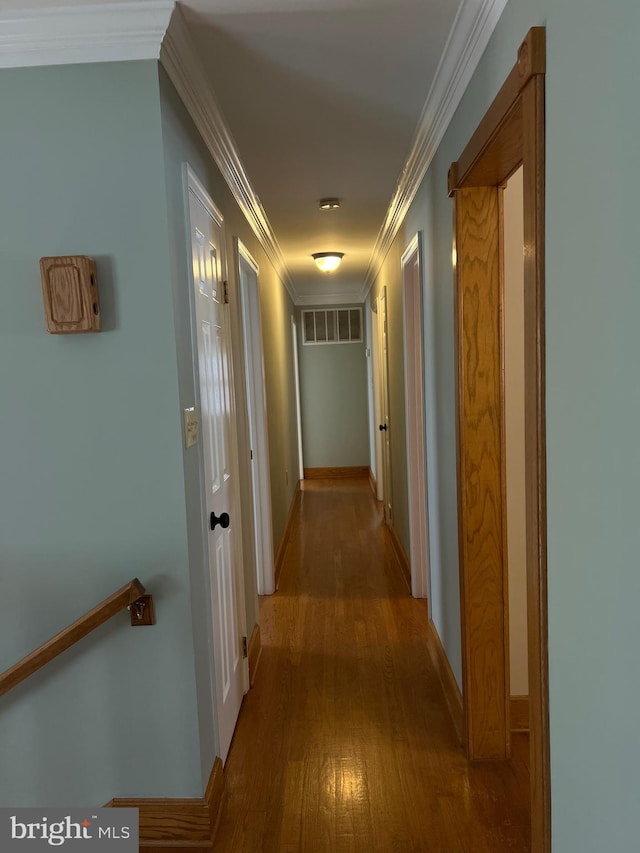 hall with hardwood / wood-style flooring and crown molding