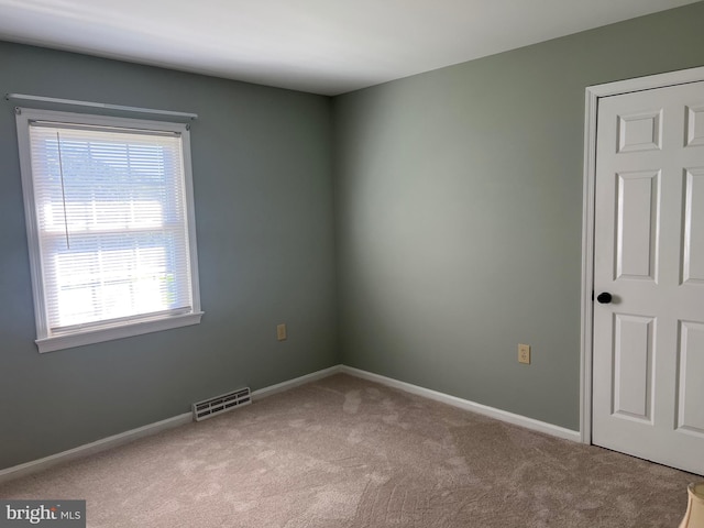 spare room featuring light colored carpet