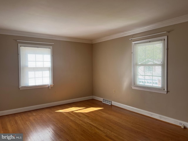 unfurnished room with hardwood / wood-style flooring and crown molding