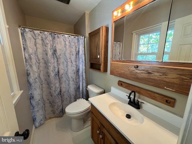 bathroom featuring curtained shower, vanity, and toilet