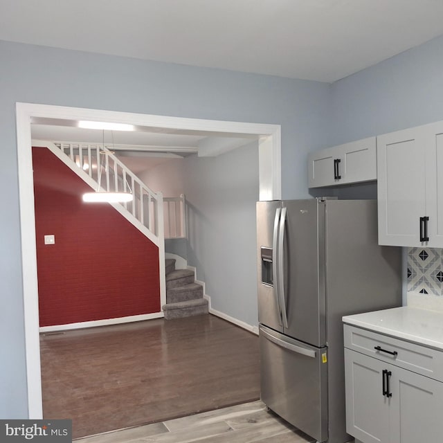 kitchen featuring stainless steel fridge with ice dispenser, white cabinets, and hardwood / wood-style flooring