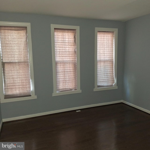 spare room with dark wood-type flooring