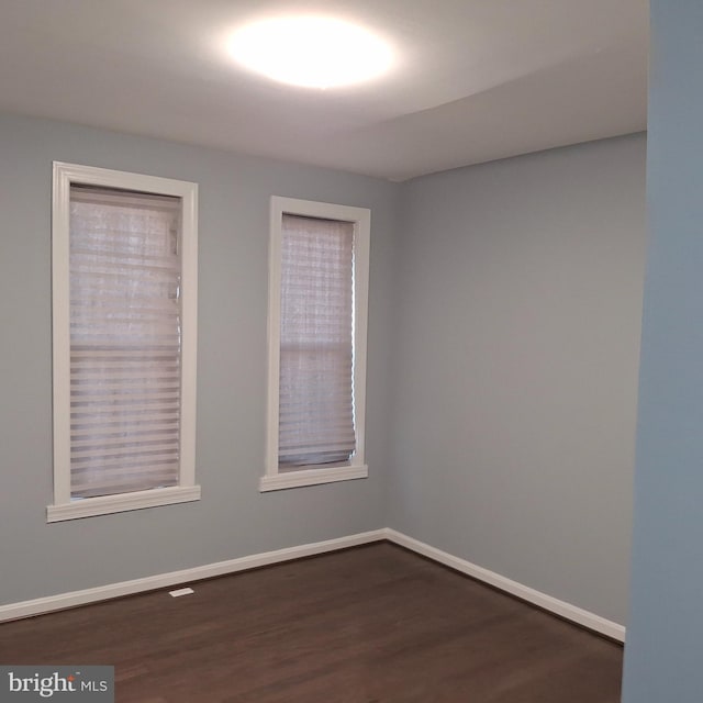 unfurnished room with dark hardwood / wood-style flooring