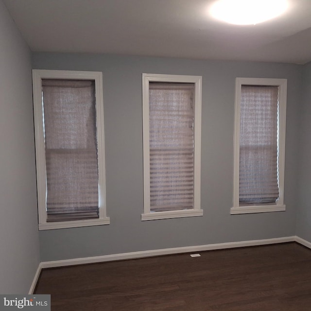 empty room with dark wood-type flooring