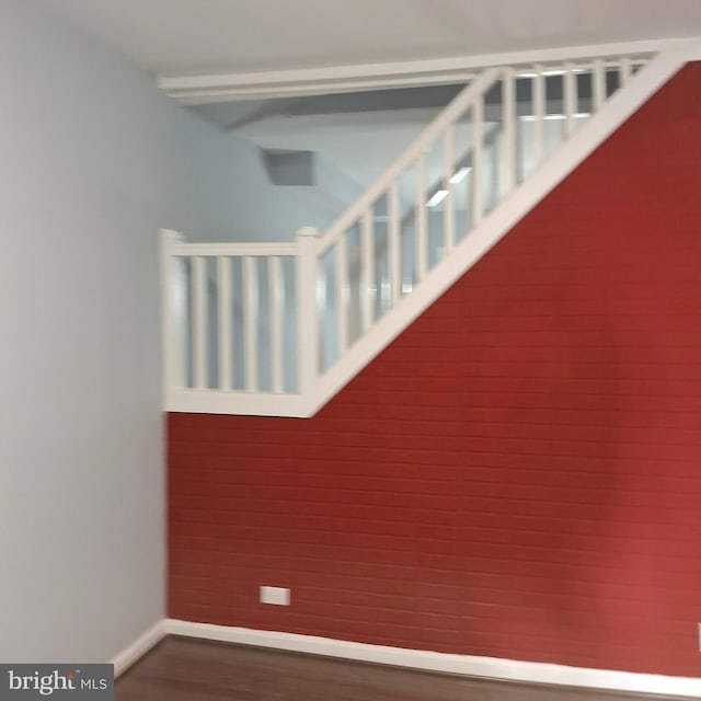 staircase with wooden walls and hardwood / wood-style floors