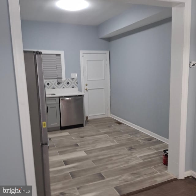 clothes washing area with washing machine and clothes dryer and light hardwood / wood-style floors