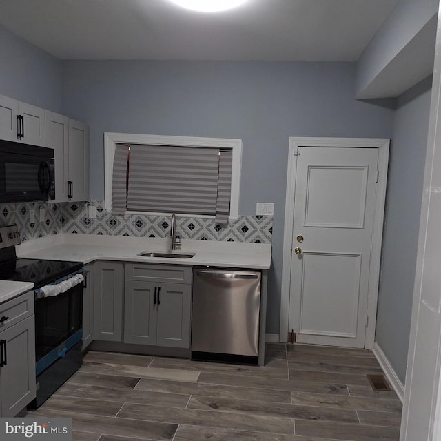 kitchen with backsplash, dark wood-type flooring, sink, stainless steel dishwasher, and range with electric stovetop