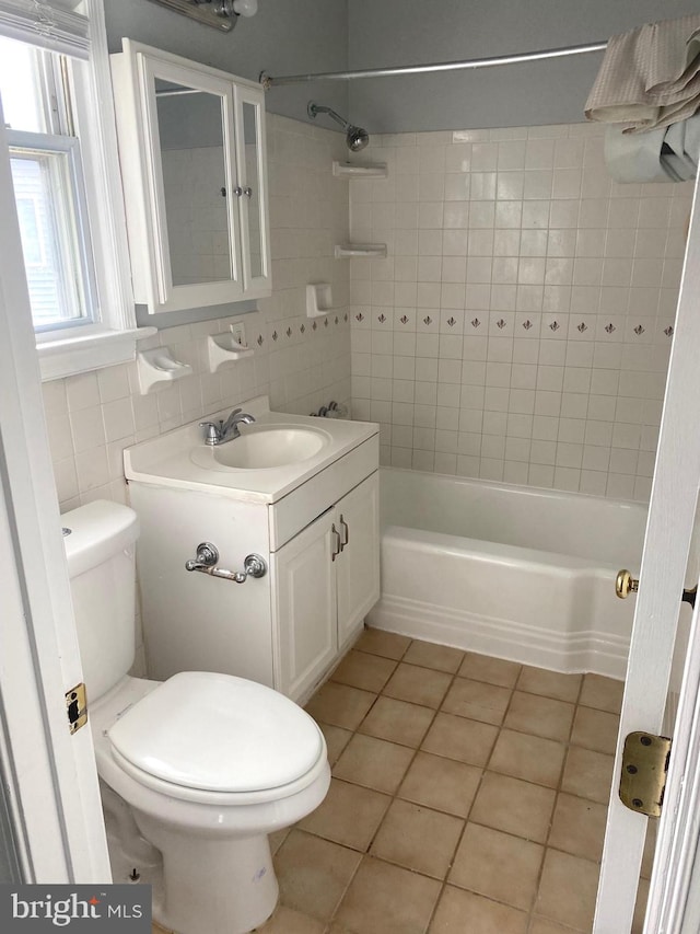 full bathroom featuring toilet, tile walls, tile patterned flooring, tasteful backsplash, and vanity