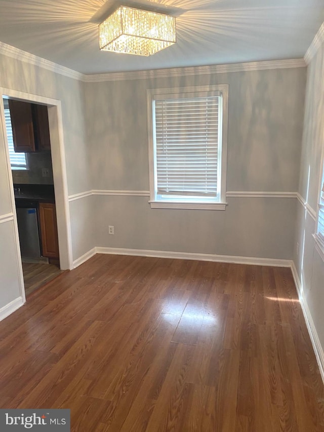 empty room with dark hardwood / wood-style flooring and ornamental molding