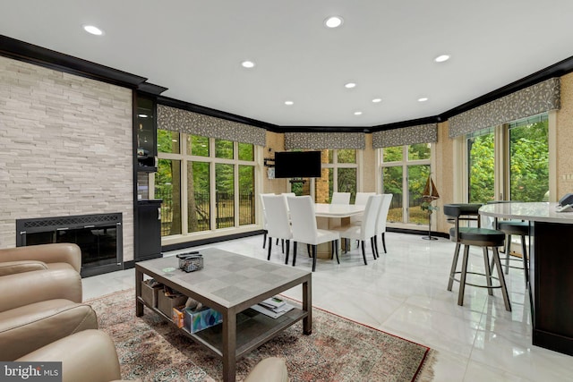 living room featuring ornamental molding, a fireplace, and plenty of natural light