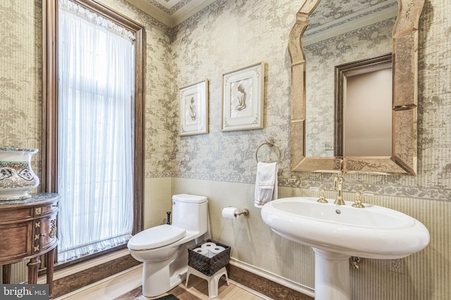 bathroom with toilet, hardwood / wood-style floors, and ornamental molding