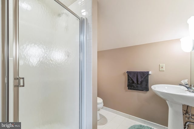 bathroom featuring toilet, sink, tile patterned floors, and a shower with door